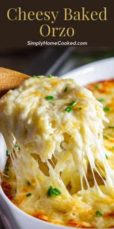 a spoonful of cheesy baked orzo is being lifted from the casserole dish