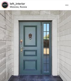 a blue front door with two sidelights and a black tile floor next to a white brick wall