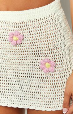 a close up of a person wearing a white skirt with pink flowers on the side