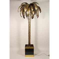 a golden palm tree lamp on a white background