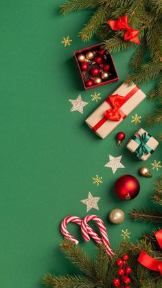 christmas decorations and gifts on green background with stars, candy canes and candies