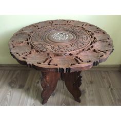 an old wooden table with carvings on the top and bottom, sitting in a room