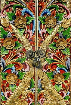 an ornately decorated wooden door with metal handles