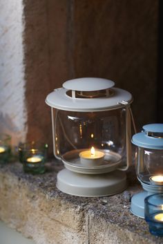 several lit candles sitting on top of a ledge