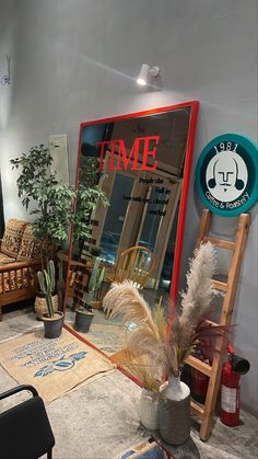 a room filled with lots of furniture and plants in front of a large mirror on the wall