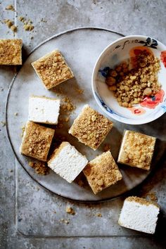 several pieces of cake sitting on top of a plate next to a bowl of cereal