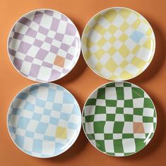 four plates with different designs on them are arranged in a grid pattern, one is green and the other is yellow