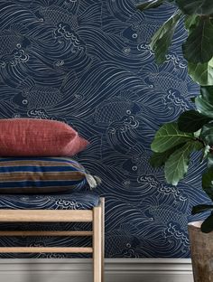 a blue wallpaper with waves on it next to a plant