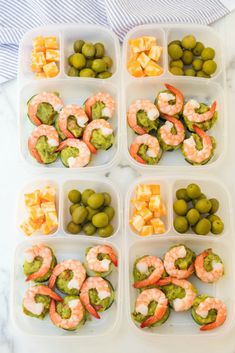 several trays filled with different types of food on top of a marble countertop