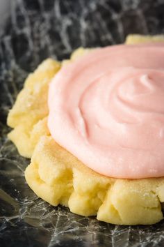 a cookie with pink icing sitting on top of it