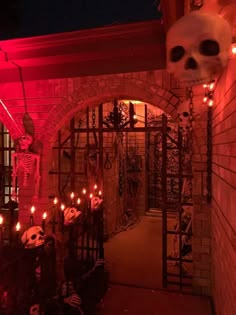 an archway decorated with halloween decorations and lite up candles in the shape of skulls