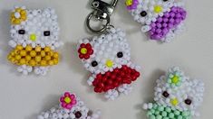 four hello kitty beaded keychains on a white surface