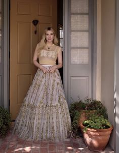 a woman standing in front of a door wearing a dress