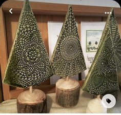 three decorative trees are on display in a room