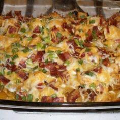 a casserole dish with bacon, cheese and green onions in it sitting on a stove top