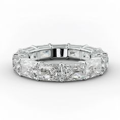 a white gold ring with princess cut diamonds on the sides and baguetts in the middle