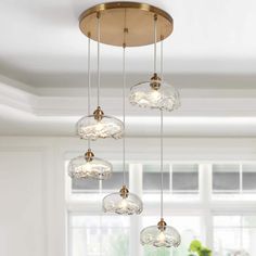 a chandelier with five glass globes hanging from it's ceiling in front of a window