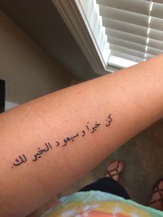 a woman's arm with an arabic writing tattoo on the left side of her arm