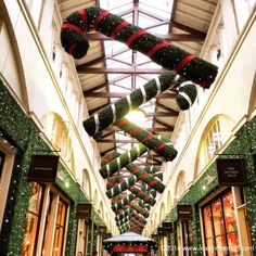 christmas decorations are hanging from the ceiling in a shopping mall