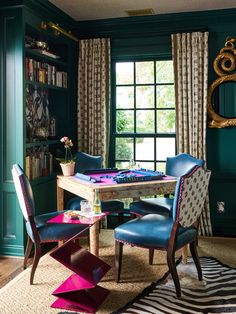 a dining room with green walls and blue chairs