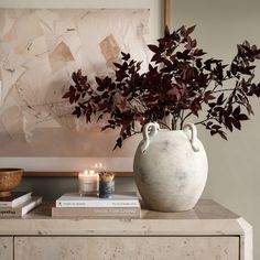 a vase filled with flowers sitting on top of a table next to two books and a candle