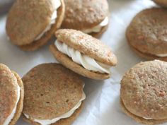 several cookies with white frosting on them sitting on wax paper