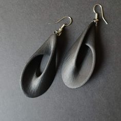 the earrings are made out of wood and have tear shaped shapes on them, with gold hooks