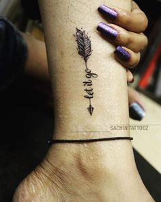 a woman's foot with an arrow tattoo on the left side of her leg