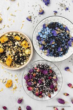 three bowls filled with different types of flowers on top of a white table next to each other