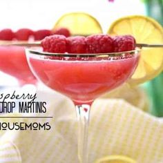 raspberry lemon drop martinis are served in coupe glasses with garnishes