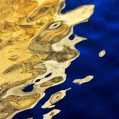 an abstract painting with blue and yellow colors on the water's surface is shown