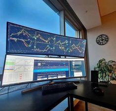 two computer monitors sitting on top of a desk