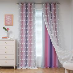 a bedroom with pink curtains and white polka dots on the drapes in front of a window