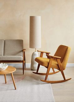 a living room filled with furniture and a lamp on top of a wooden table next to a chair