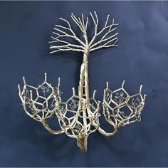 a sculpture made out of branches on a blue background