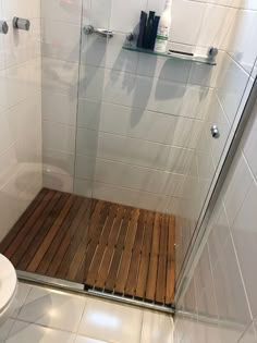 a bathroom with a wooden floor next to a white toilet