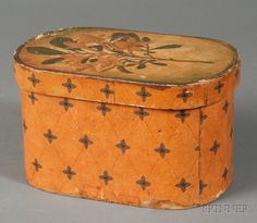 an old wooden box with floral designs on the lid and sides, sitting on a gray surface