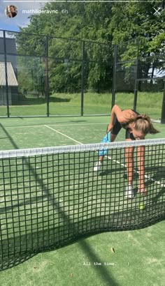 a woman is bending over on the tennis court