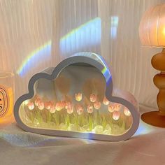 a decorative cloud shaped mirror next to a lit candle