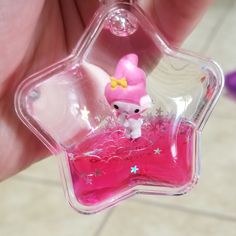 a person holding a small pink object in their hand and it is shaped like a star