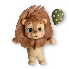 a lion figurine holding a balloon with polka dots on it's tail