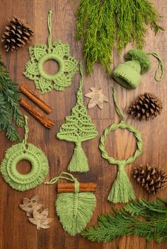 green crocheted ornaments and pine cones on a wooden surface with needles, cinnamon sticks, firs and leaves