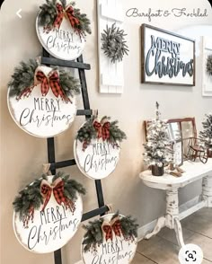 christmas decorations are hanging on the wall in front of a white table and chairs with red bows