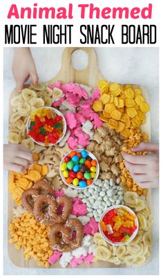 an animal themed movie night snack board with candy, cereal and pretzels on it