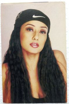 a woman with long black hair wearing a nike headband and posing for a photo