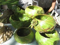 some artichokes are sitting on a table with people in the back ground