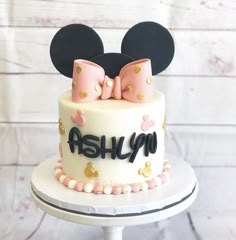 a minnie mouse cake with pink and gold decorations