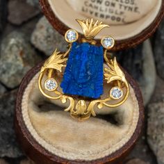 This lovely circa 1900 18K yellow gold Egyptian revival pin features an engraved floral design, centered with a lapis carving of a face. The lapis is accented with four (4) bezel set, round old European cut diamonds. The pin measures 24.1mm long by 20.9mm wide and is finished with a sturdy 14K yellow gold hinged and locking pin back and charm hook. Egyptian Revival Jewelry, Egyptian Jewelry, Egyptian Revival, Diamond Brooch, European Cut Diamonds, Fantasy Fashion, Jewelry Case, Pin Backs, Licorice