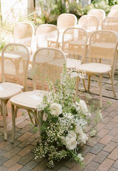 a bunch of chairs that are sitting on the ground with flowers in front of them