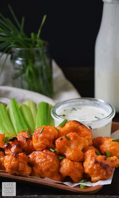 some food is sitting on a tray with celery and ranch dressing in the background